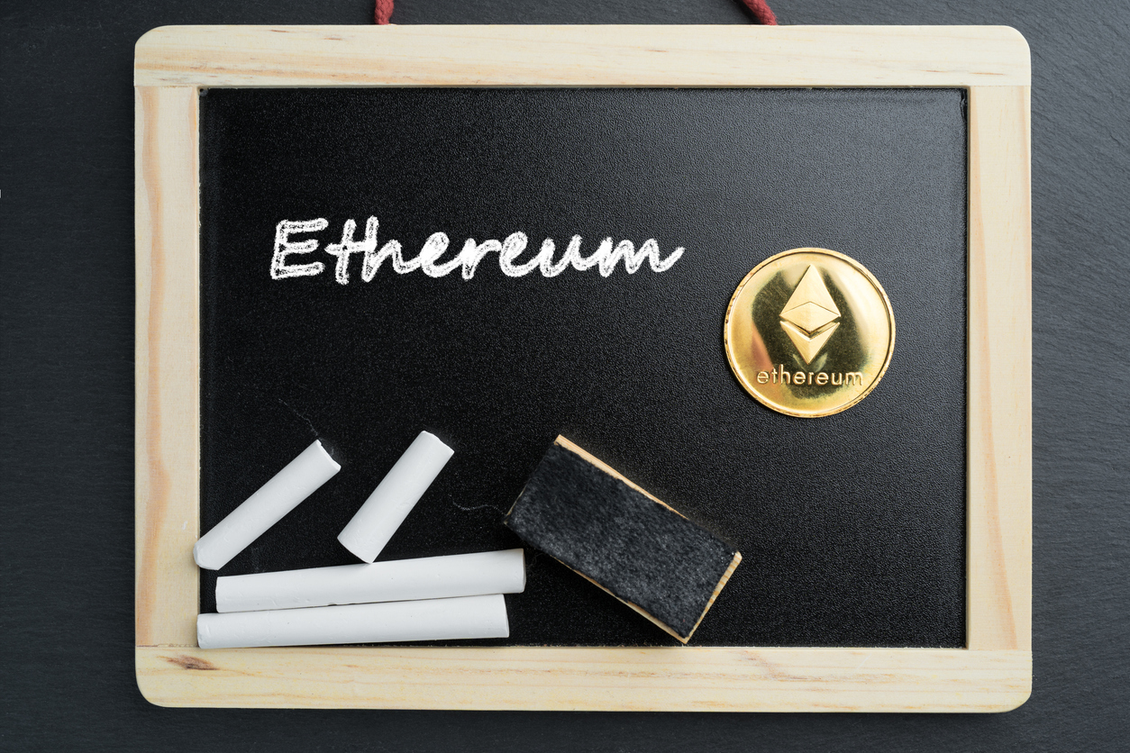 Physical Ethereum gold coin on a blackboard with chalk text. Cryptocurrency education abstract concept.