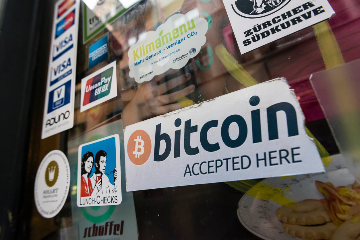 sign 'bitcoin accepter here' on front of storefront with other signs