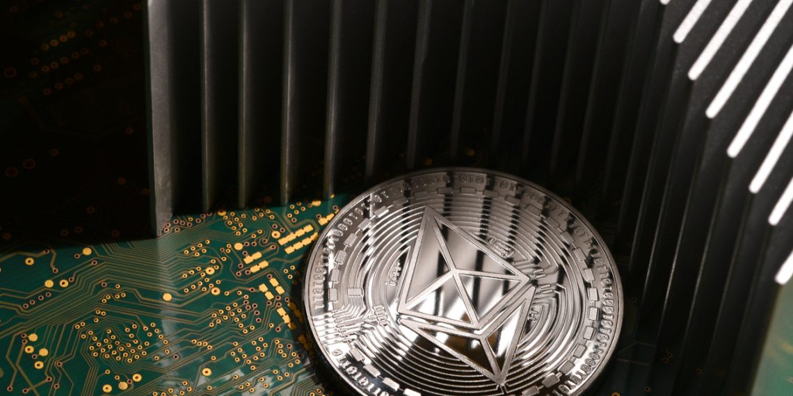 Florence, Italy - June 2019: close-up of Ethereum ETH cryptocurrency over printed electronic circuit board with aluminum heatsink.