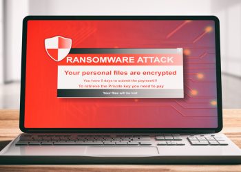 Ransomware attack on a computer laptop screen, wooden desk. 3d illustration