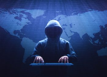 Anonymous computer hacker sitting in front of a virtual screen.