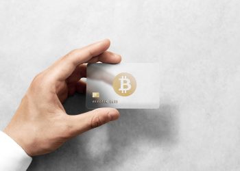 Hand holding bitcoin card template with rounded corners and embossed gold logo. Plain plastic cryptocurrency payment-card display front, design mock up. Electronic mining template.