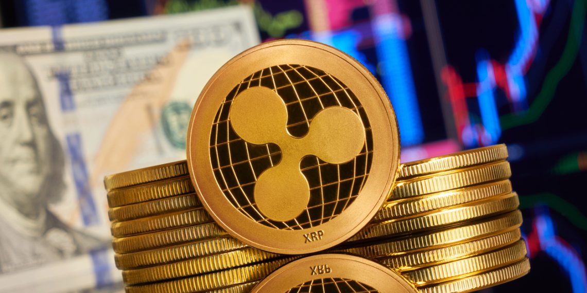 Gold ripple stacked on a bright background of business graphics close-up. Ripple XRP cryptocurrency.