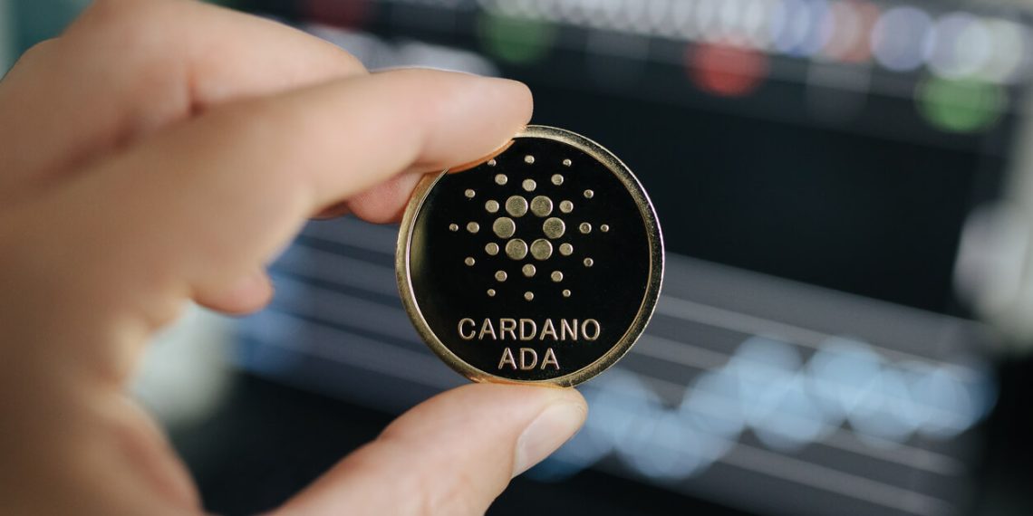 Cardano ada coin held in hand